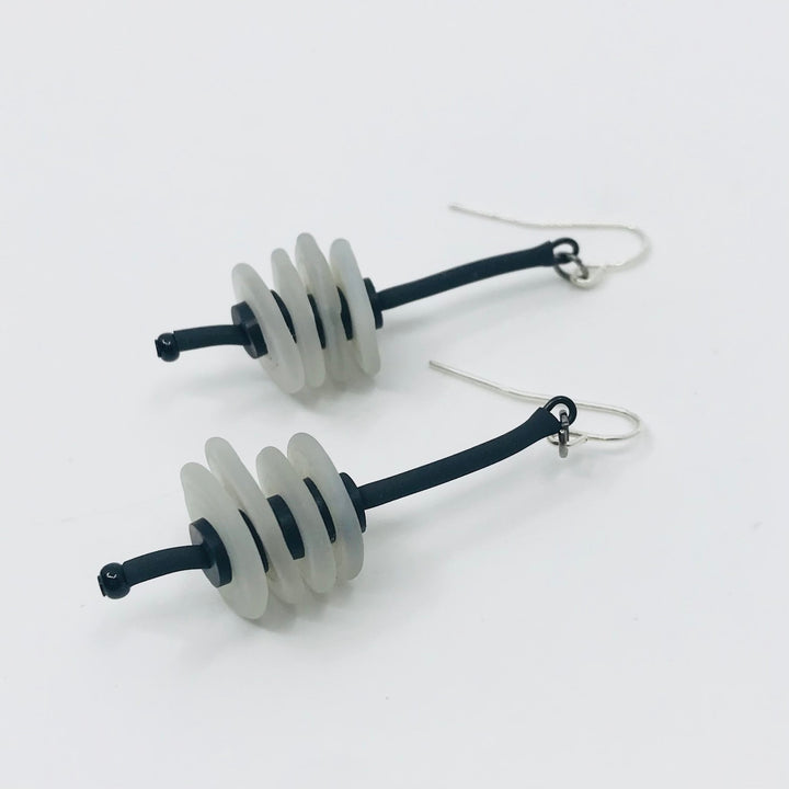 Earrings of flat glass beads with black rubber cord, from the Stack series.
