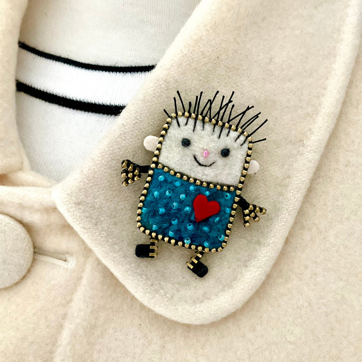 Embroidered character with a red heart on a white fabric background