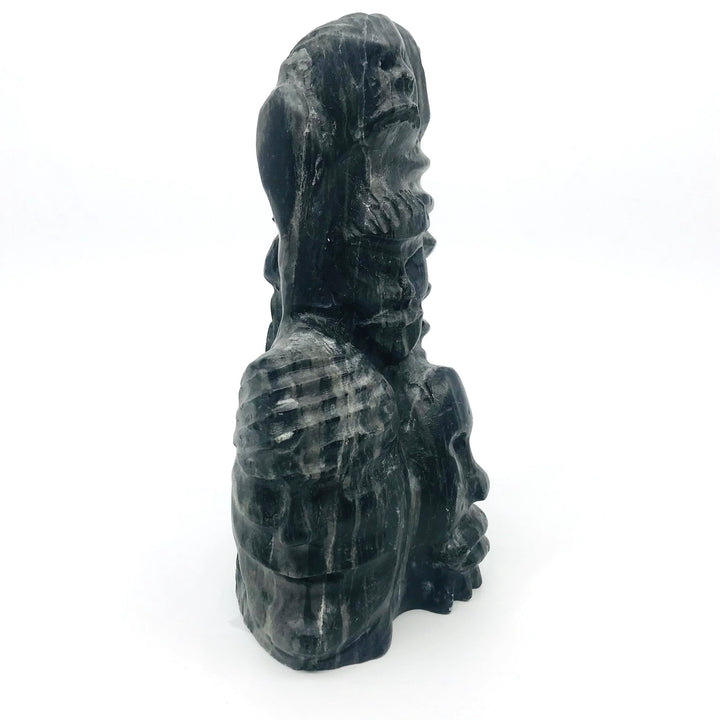 Faces in black serpentine carving by Silas Aittauq