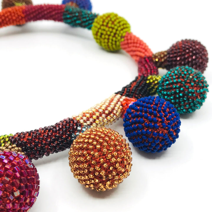 Balloon Necklace. Multicoloured glass beads are woven together with red-orange thread. 46cm long (18"), with a strong magnetic clasp.