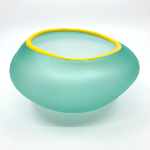 Supernatural bowl in teal green, with yellow rim. 18 x 19 x 11 cm.