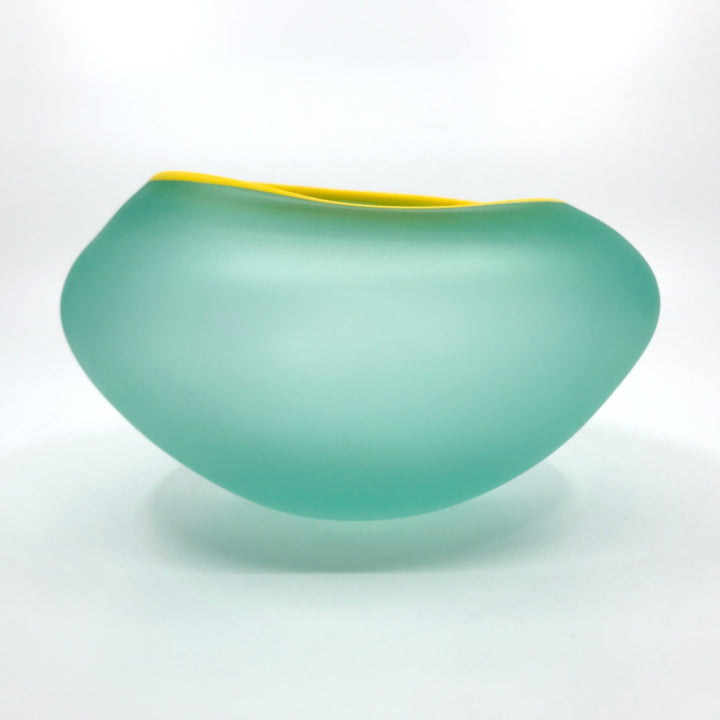 Supernatural bowl in teal green, with yellow rim. 18 x 19 x 11 cm.