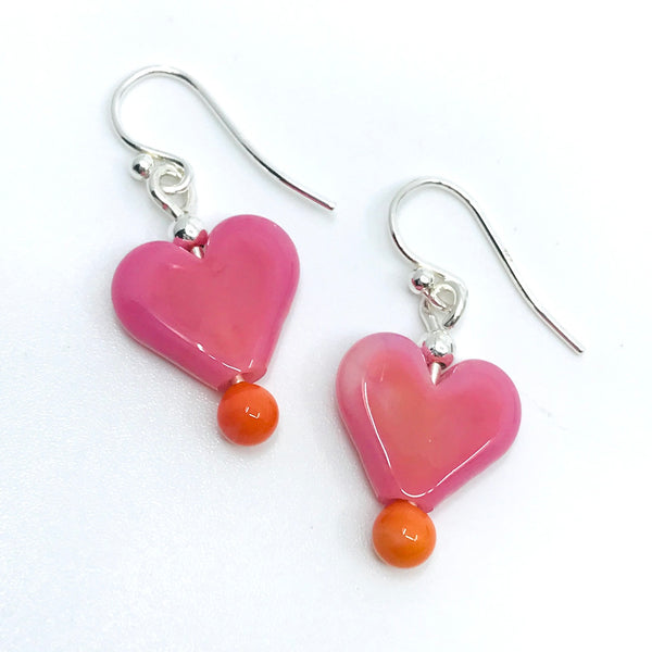 Flame-worked glass heart earrings in pink.
