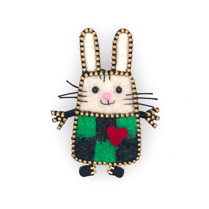A decorative fibre brooch featuring a white rabbit with a black and green checkered outfit, adorned with a red heart and rhinestone details.