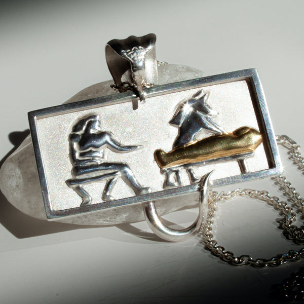 Silver pendant with a design of a person and a horse