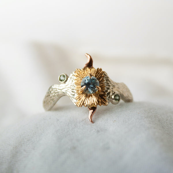 Gold and silver ring with a central gemstone