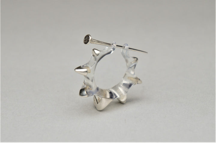 Earlobe Destroyer 2.0, 2021.  Created hand fabrication and CAD (3D modelling), this single earring is made of sterling silver and resin.  3.7 x 1 x 3.2 cm