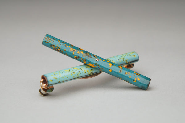 Handle, 2023.  Created with hand fabrication and enamelling, this brooch is made of copper, enamel, nickel, and steel.  8.3 x 2.4 x 1.8cm (8.3 x 2.4 x 8cm when opened)