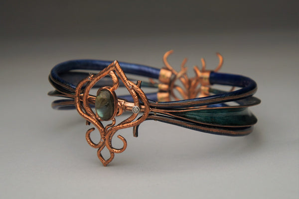 Madness of Spiculums, 2023.  Created with hand fabrication, enamelling, and spiculum forming, this neckpiece is made of copper, enamel, brass, sterling silver, cubic zirconia, and labradorite. The clasp is magnetic.  15 x 13 x 7 cm
