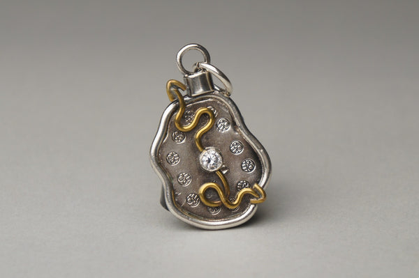 Melting Clock, 2020.  This hand fabricated pendant is made of fine silver, brass, and cubic zirconia.  5.5 x 3 x 0.6 cm