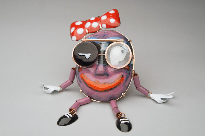Mr. Trashface, 2023.  Created with hand fabrication, chase and repousse, and enamelling, this brooch is made of copper, enamel, acrylic, brass, and steel.  16 x 8 x 2.4 cm