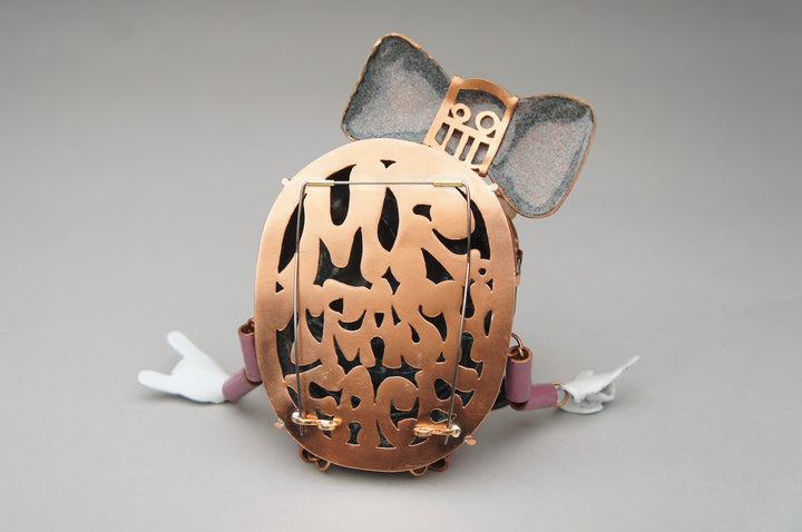 Mr. Trashface, 2023.  Created with hand fabrication, chase and repousse, and enamelling, this brooch is made of copper, enamel, acrylic, brass, and steel.  16 x 8 x 2.4 cm