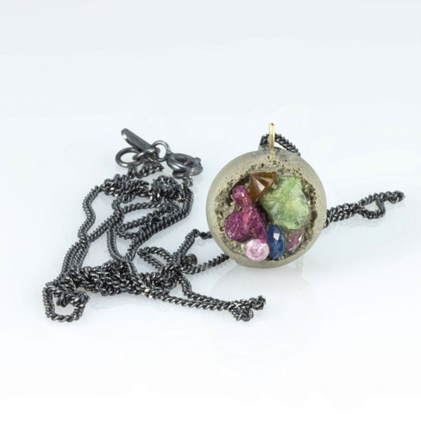 Necklace with a round pendant featuring small figurines on a white background