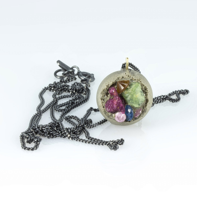 Necklace with a round pendant featuring small figurines on a white background