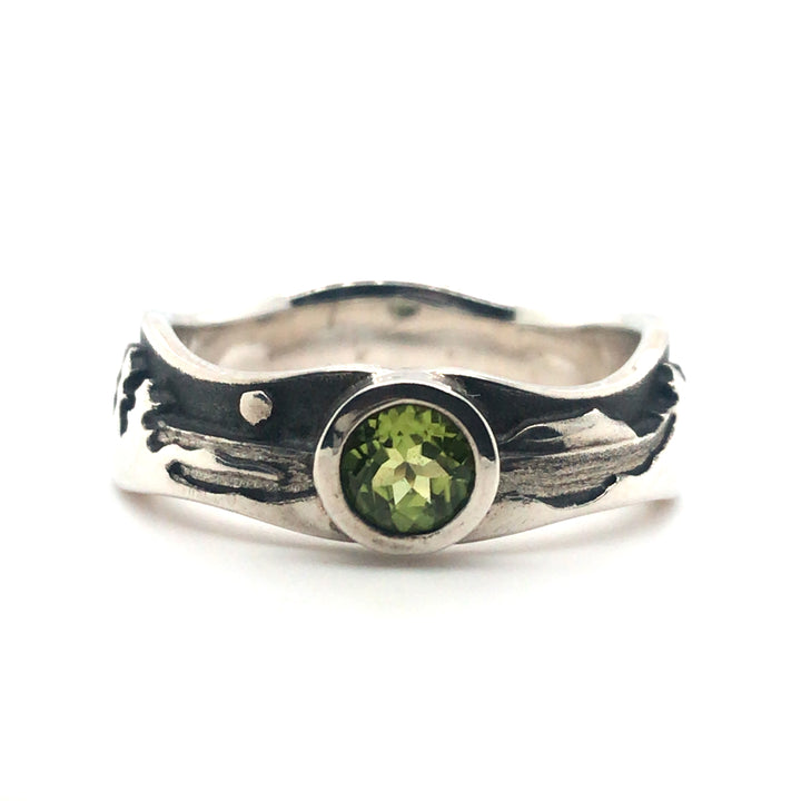 Peridot landscape at night ring in polished sterling silver against the oxidized matte black sky