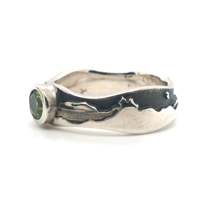 Peridot landscape at night ring in polished sterling silver against the oxidized matte black sky