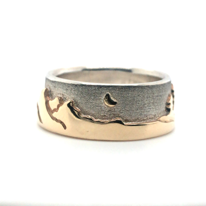 Two tone Shoreline Ring with a brushed sterling silver sky backdrop for the rugged mountains with moon, and sun above the trees and lake in impressive depths of polished 14k yellow gold. 