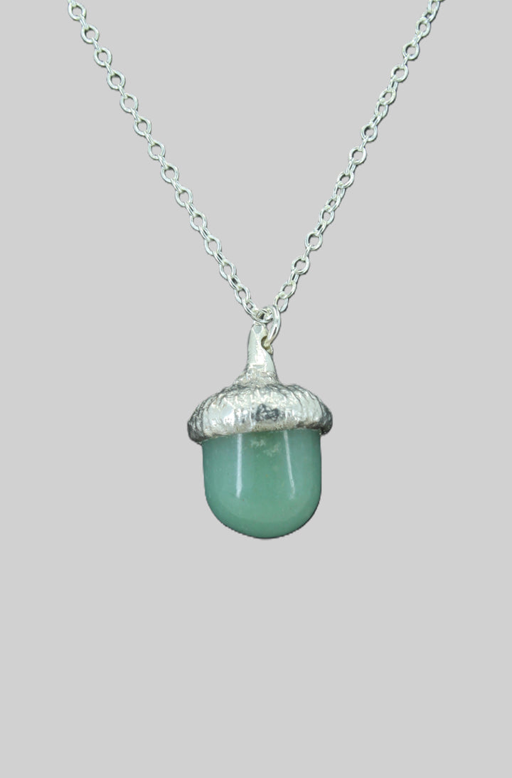 Necklace with a green acorn pendant on a light gray background