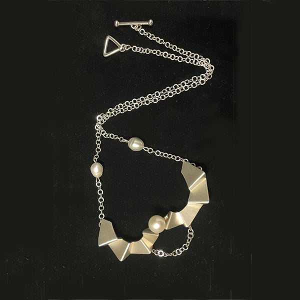Ladder of human progress necklace, 2022.  Sterling silver necklace with a 12mm and 10mm white pearls. The silver elements were created utilizing 3D printing technology.  7.5 × 4.5 × 1.5 cm