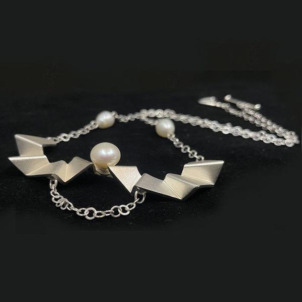 Ladder of human progress necklace, 2022.  Sterling silver necklace with a 12mm and 10mm white pearls. The silver elements were created utilizing 3D printing technology.  7.5 × 4.5 × 1.5 cm