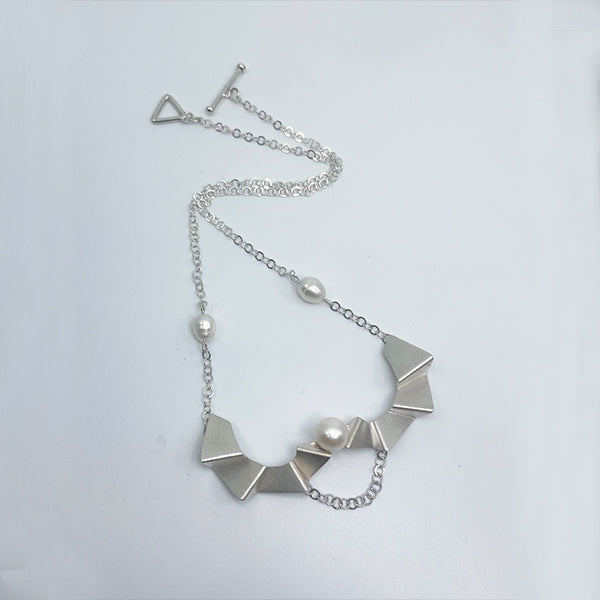 Ladder of human progress necklace, 2022.  Sterling silver necklace with a 12mm and 10mm white pearls. The silver elements were created utilizing 3D printing technology.  7.5 × 4.5 × 1.5 cm