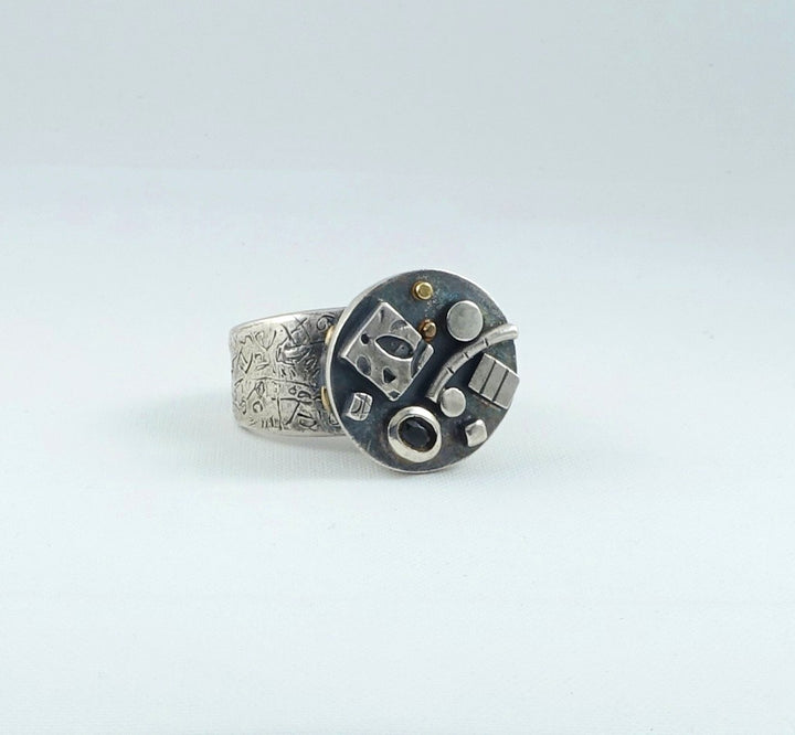 Silver ring with geometric design on a light gray background