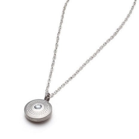 The Revolutio Collection. This necklace is made from reclaimed titanium, taken from the waste bin of a titanium aerospace supplier and lab-grown diamonds. The textures are worked on a lathe. 12mm disk, 2.3mm diamond, 16 inch chain.