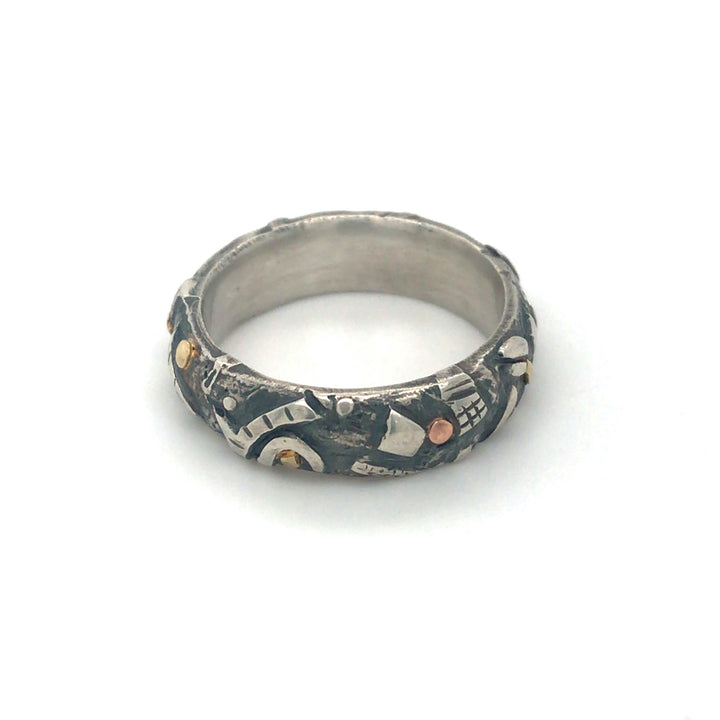 "Forest floor" ring of sterling silver, with oxidization and 14k/18k details. The shapes of branches, leaves and stones fully surround the 6mm band. Size 7.75