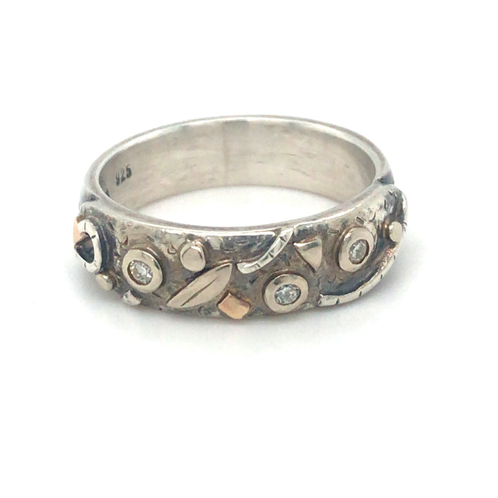 Three diamonds bezel-set in gold with additional gold and silver details on this bright and dark band unisex forever ring. The 0.6 cm width makes it a perfect stacking ring in a size 8.