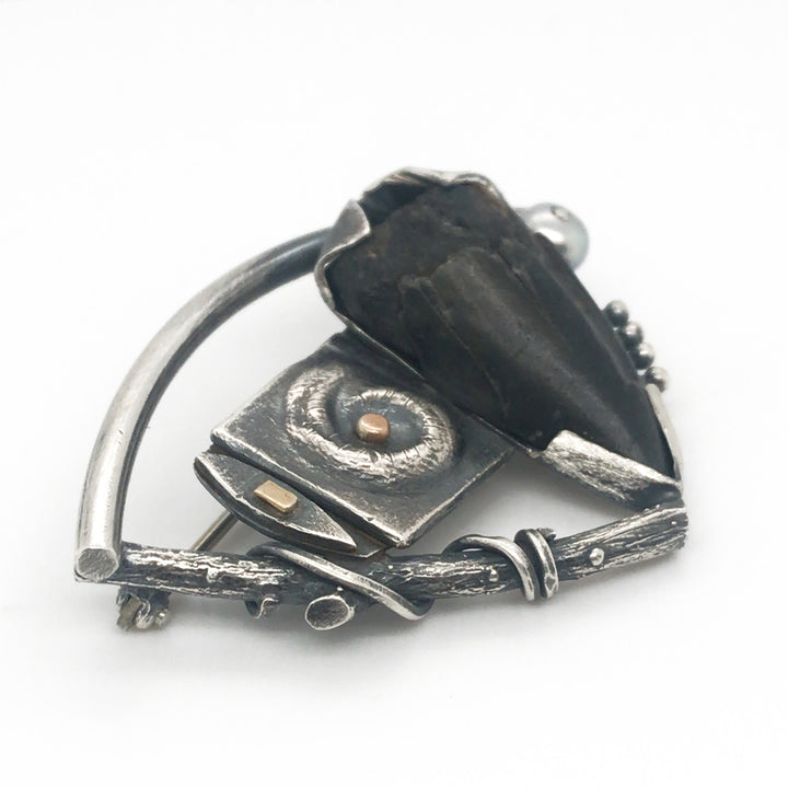Fossilized shark's tooth set in sterling silver with gold details and a grey pearl, 5x3x1 cm.