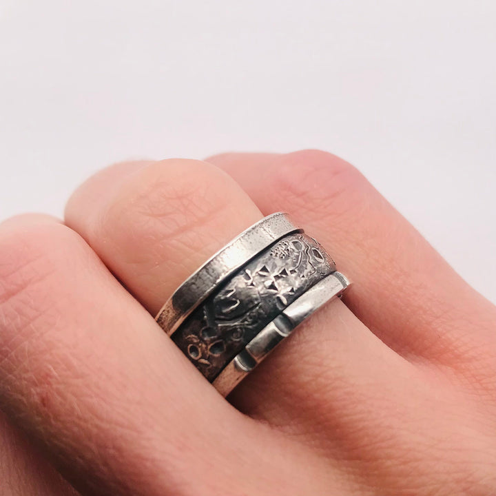 A handsome sterling silver stacked ring that combines three bands in one. A size 7.5 and 0.5 cm wide, this unisex ring is a strong combination of texture and geometry.