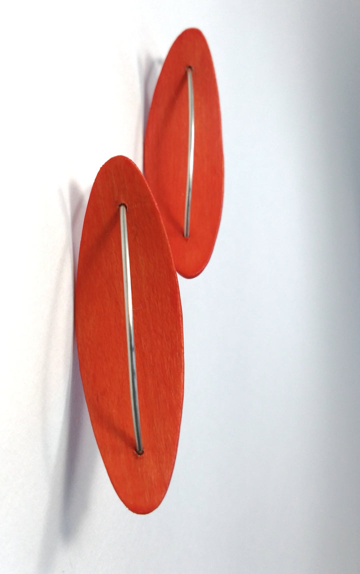 Bright Coral Reverse Pod earrings, 2023. Hand laminated and bent maple wood earrings, with sterling silver and acrylic polymer.