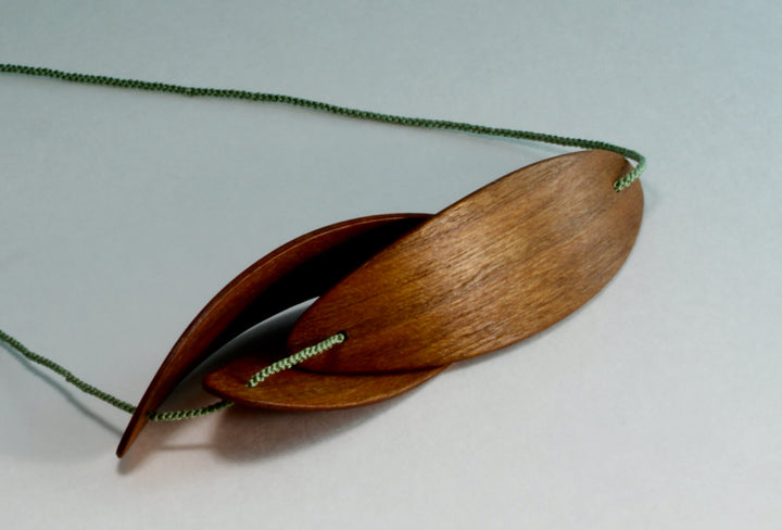 Pod 1 necklace, 2017. Laminated bent cherry wood and hand-corded silk. 