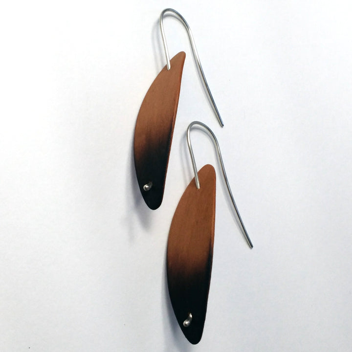 Burnt Cherry Pod earrings, 2023. Hand laminated, bent, and burnt cherry wood earrings, with sterling silver posts.