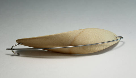 Curled Pod brooch 1, 2018. Laminated bent maple wood and stainless steel.