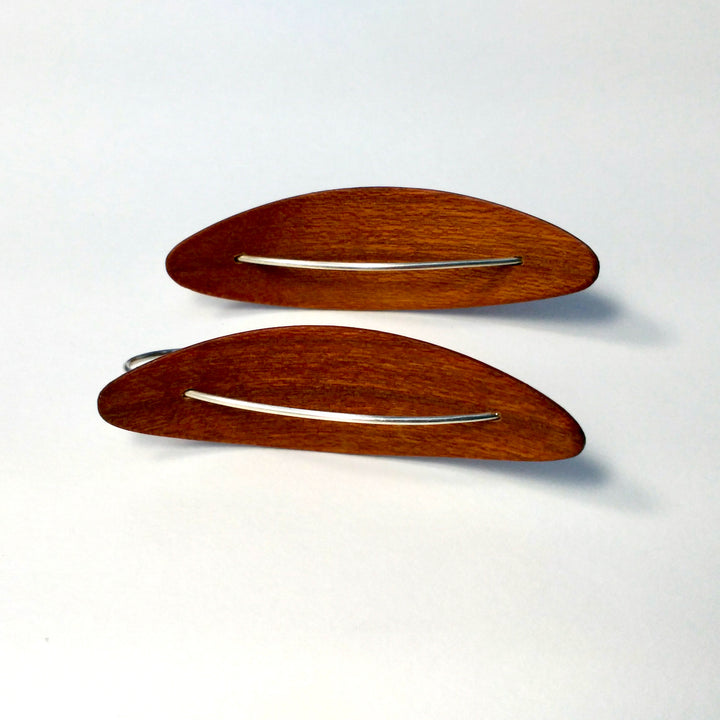 Medium Reverse Pod cherry earrings, 2023. Hand laminated, bent, and oiled cherry wood earrings, with sterling silver hooks.