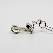 A ribbon-like hand forged sterling silver pendant on a 22" snake chain with a magnetic clasp. 6 x 3 x 1.5 cm