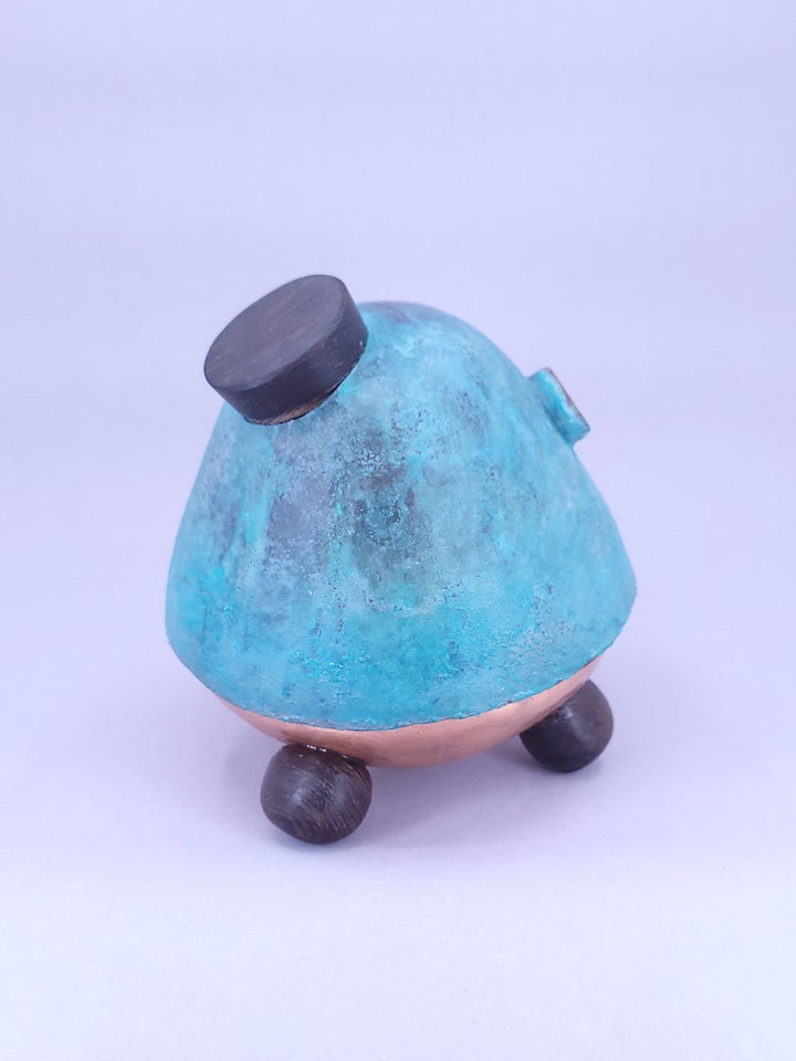 Happy Teapot Piggy Bank - A smiling teapot-shaped piggy bank of cheerful blue patinated copper, with copper and glass googly eyes. 