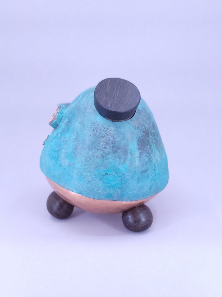 Happy Teapot Piggy Bank - A smiling teapot-shaped piggy bank of cheerful blue patinated copper, with copper and glass googly eyes. 
