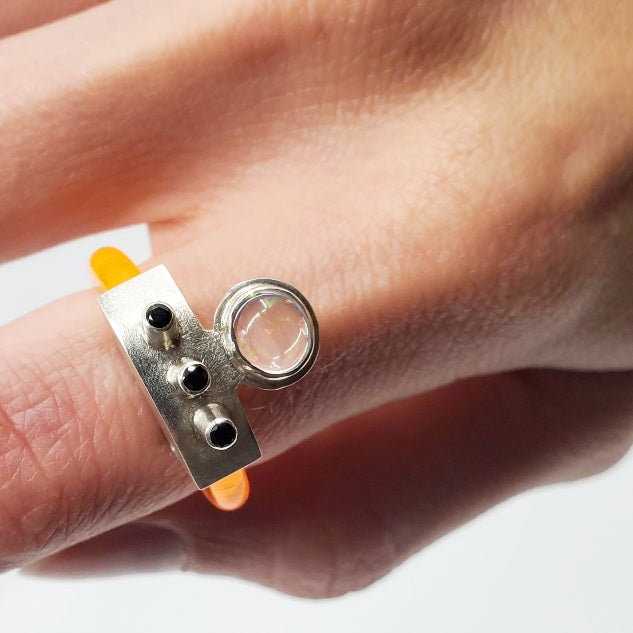 Anna Lindsay MacDonald Laika Doublet, in flouro orange, perfect for ring stacking, set with opal cabochon and three black spinels. Hand fabricated in sterling silver. 