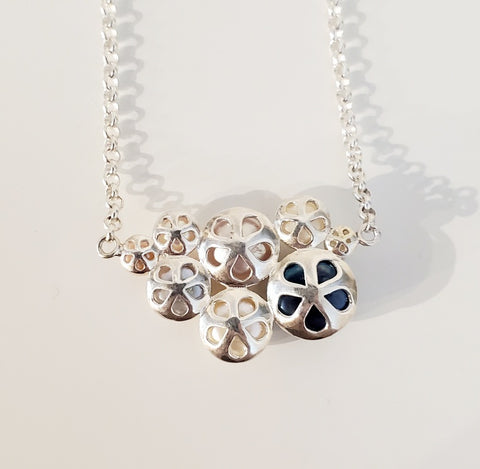 Annie Tung Blush pendant, horizontal placement of freshwater button pearls in sterling silver, with a fine chain. The backing of each pearl is itself beautiful, the shape reminiscent of a flower or sanddollar. View from back.
