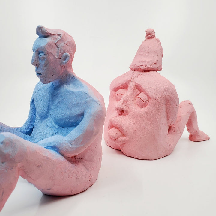 Kiss Me Baby II- small double-sided pink and blue ceramic sculpture painted with gouache. The sculpture is comprised of two sides, one of a figure and the other of a face. - WIth its counterpart