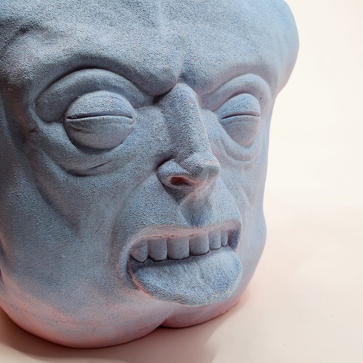 Holding Back I - large ceramic two-sided sculpture of a figure biting their tongue, with blue and pink gouache paint.