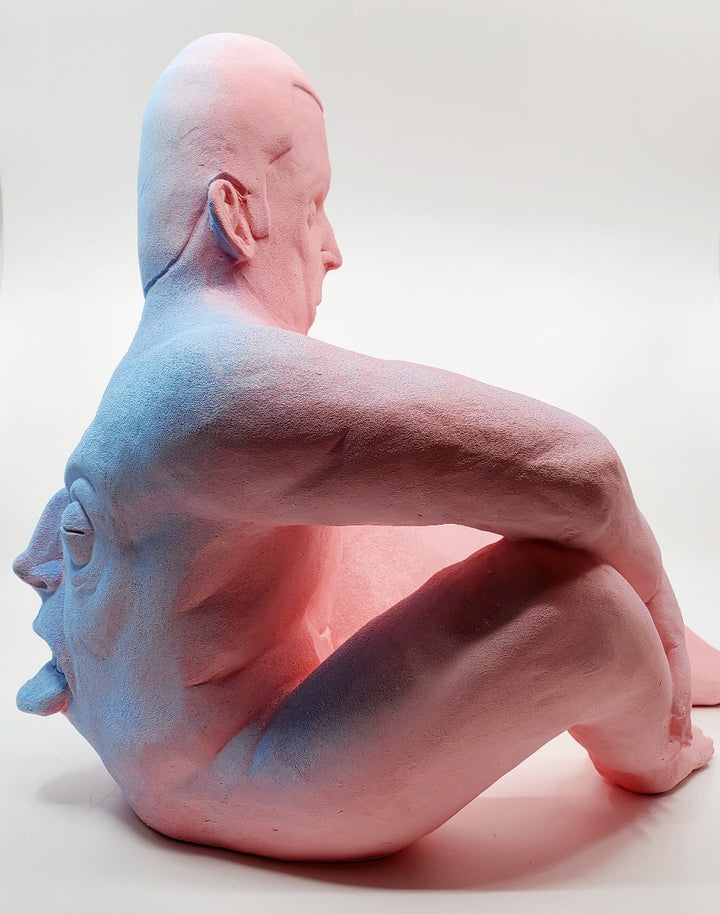Holding Back I - large ceramic two-sided sculpture of a figure biting their tongue, with blue and pink gouache paint.