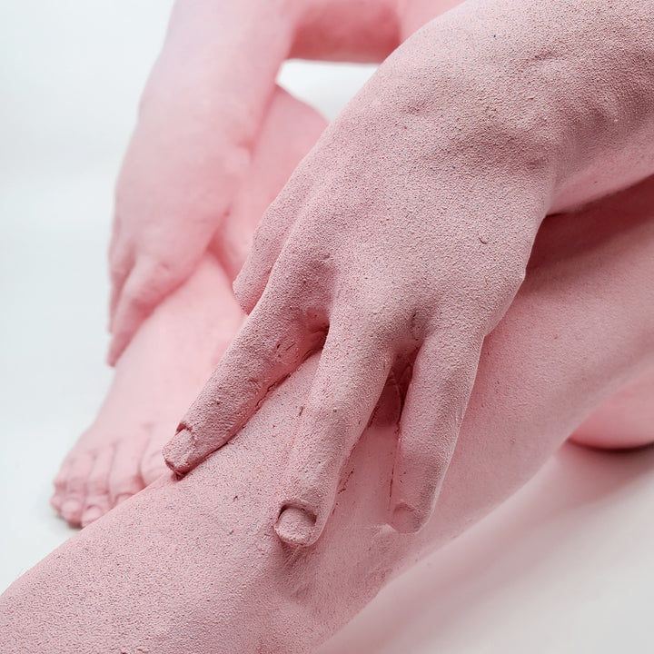 Holding Back I - large ceramic two-sided sculpture of a figure biting their tongue, with blue and pink gouache paint.