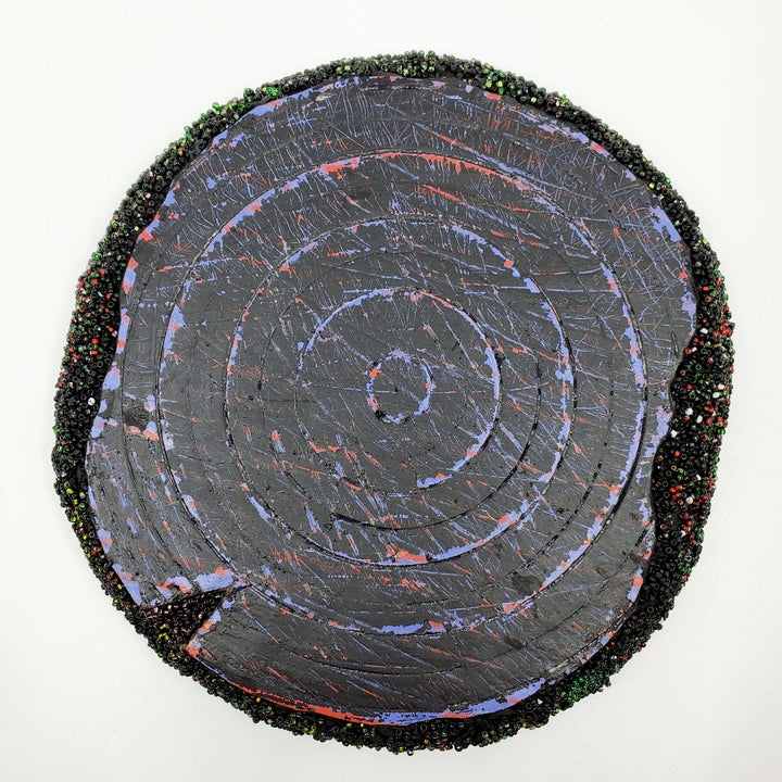 Blue & Black: Mixed media wall sculpture constructed with a corrugated cardboard base. It is painted with acrylics, and adorned with green and red glass beads.