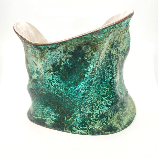 Hand formed copper cuff with sterling silver plate, chased and patinated.