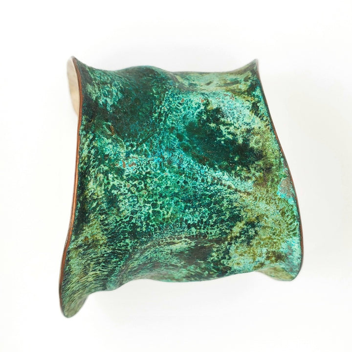 Hand formed copper cuff with sterling silver plate, chased and patinated.