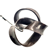 Lapel pin. Nickel knot-shaped design with sterling silver pin.
