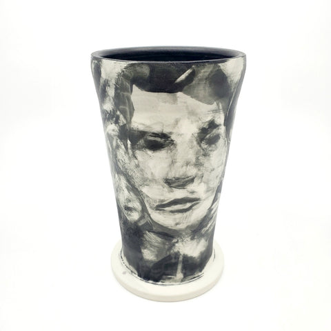 Medium ceramic vessel - 3. Hand painted porcelain vessel. Black glaze has been applied in careful layers to depict faces and patterns. 10 x 10 x 18 cm.